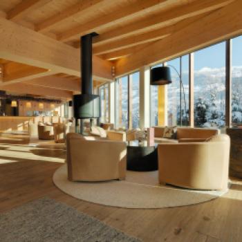 Die gemütliche Lobby mit Ausblick auf die Winterwelt des Zillertals - Kinderhotel mit Lifestyle „alpina zillertal“ in Fügen